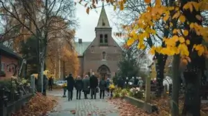 En grupp människor går mot en tegelkyrka omgiven av höstträd med gula och orange löv. De är klädda i mörka kläder, eventuellt deltar de i en sammankomst eller gudstjänst. Scenen är lugn och dyster, med mulen himmel.